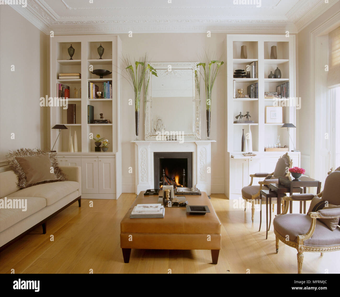 Moderno De Color Blanco Sala De Estar Con Chimenea Y Sofas Tapizados Fuego Encendido Par Otomana Del Periodo Dorado De Sillas De Madera Construida En Los Estantes Fotografia De Stock Alamy