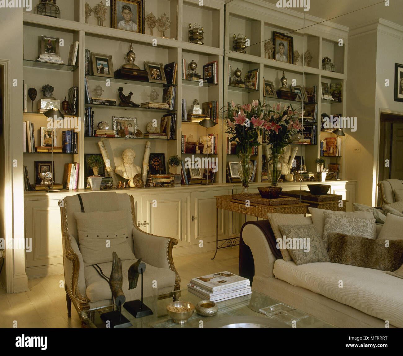 Artefactos en una estantería empotrada con sillón y sofá en el salón  neutral Fotografía de stock - Alamy