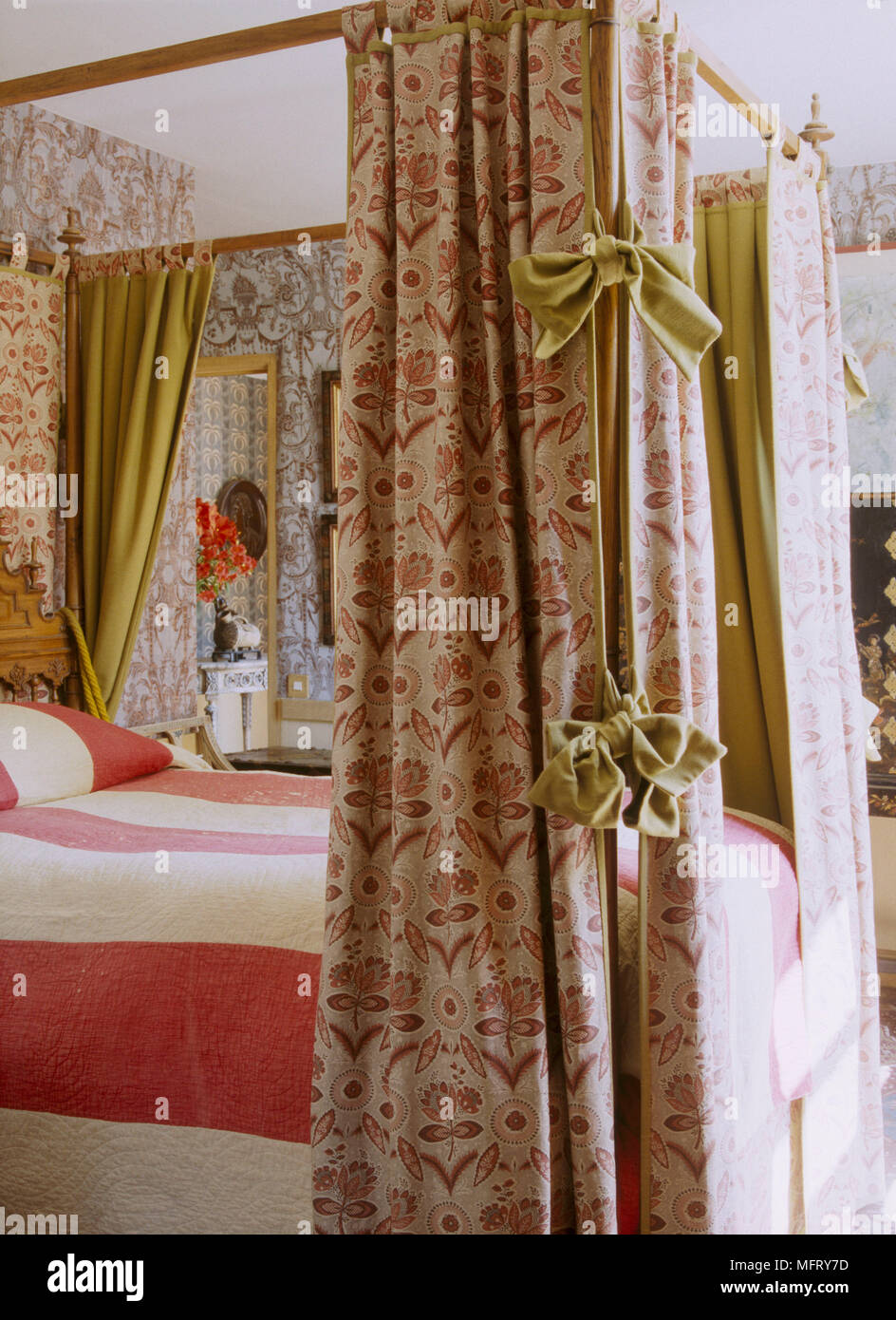 Un detalle tradicional de un dormitorio con cama de matrimonio con dosel  cortinas, colchas de patrón de rayas Fotografía de stock - Alamy