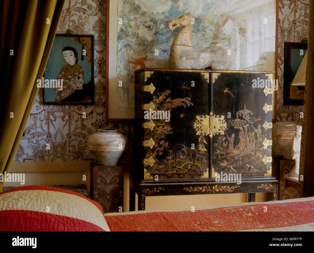 Un detalle tradicional de un dormitorio con cama con dosel cama rayas laca negra cubierta gabinete ormolu artefactos de cerámica china Foto de stock