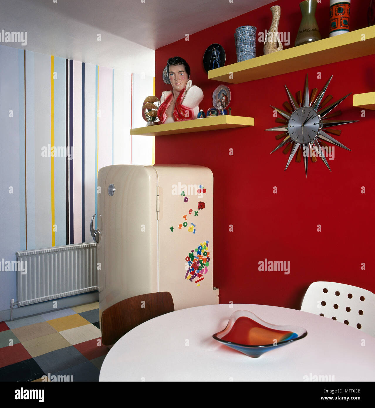 Moderno, Cocina comedor con pared de acento de color rojo brillante,  amarillo flotante Estantes, mesa blanca redonda, vintage y nevera  Fotografía de stock - Alamy