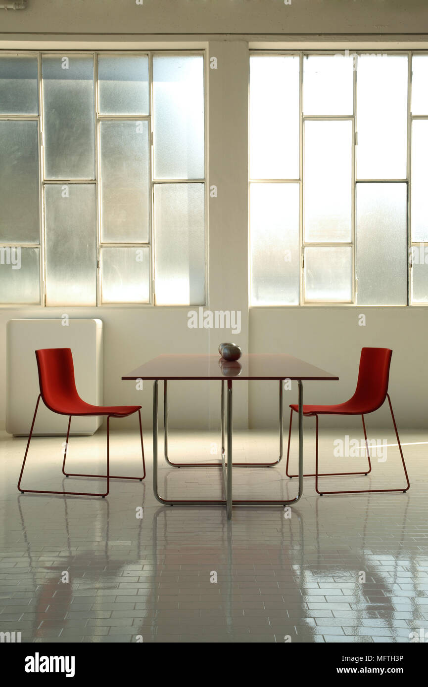 Un moderno, minimalista, comedor, sillas rojas a ambos lados de una ... Un moderno, minimalista, comedor, sillas rojas a ambos lados de una ...