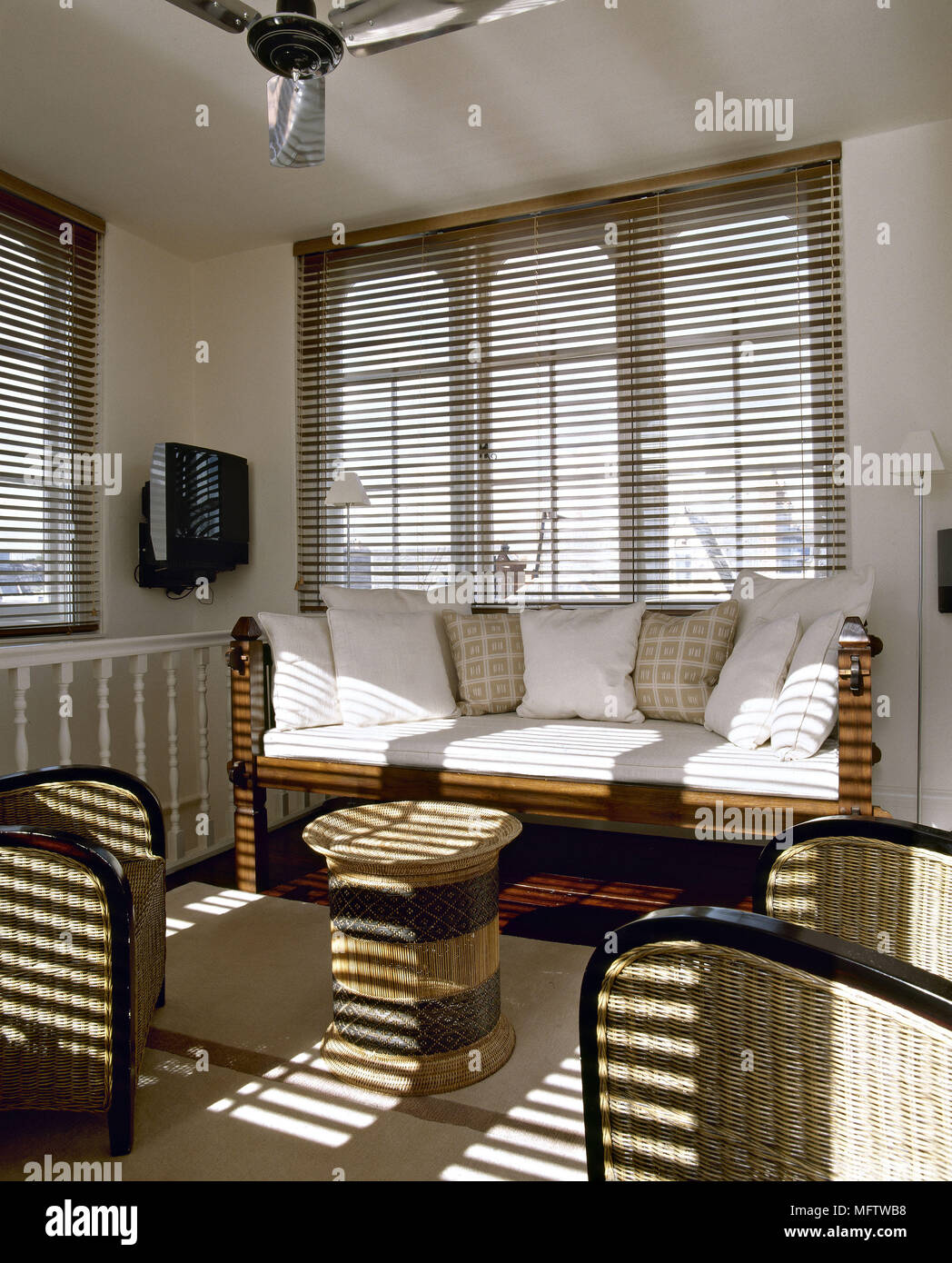 Una moderna sala de estar con sillones de mimbre ventilador sofá persianas  Fotografía de stock - Alamy