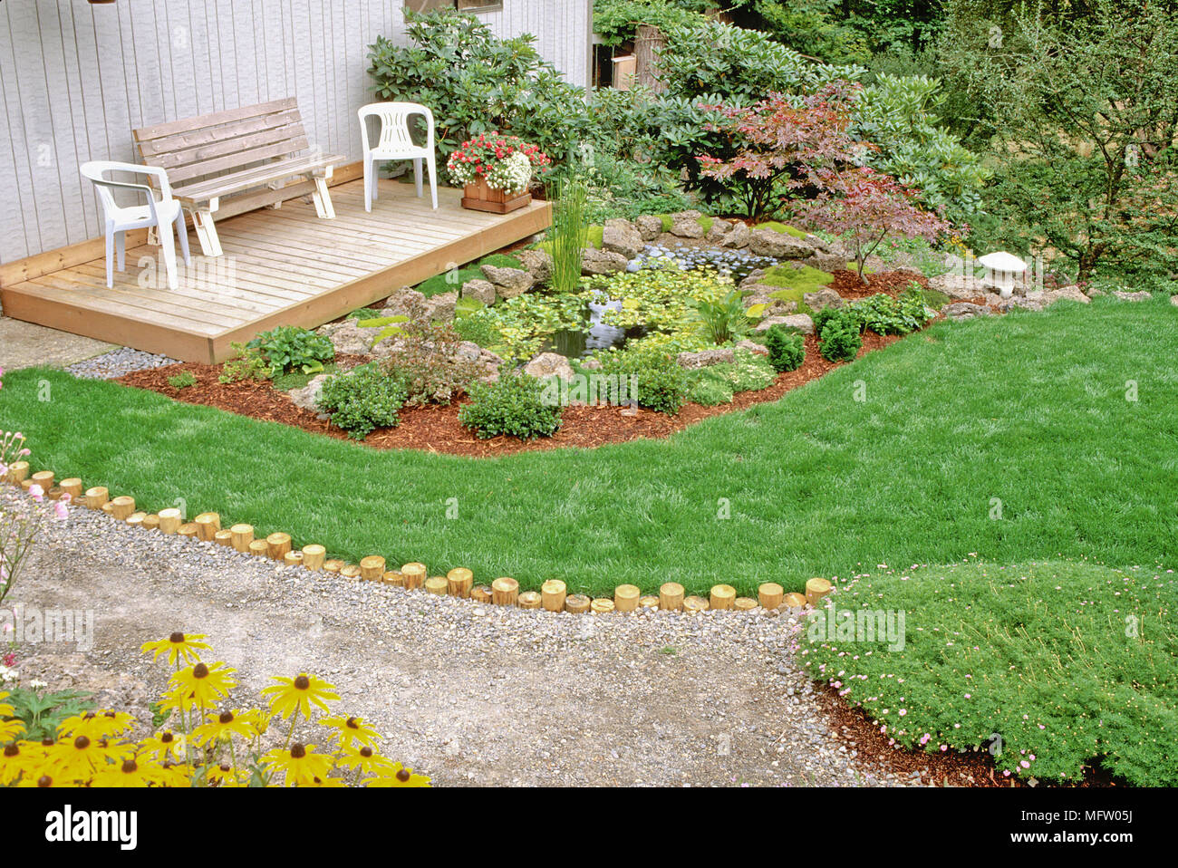 Sentarse en un decorado patio jardín plantado con Acer palmatum, Rudbeckia y Eichhornia crassipes Foto de stock