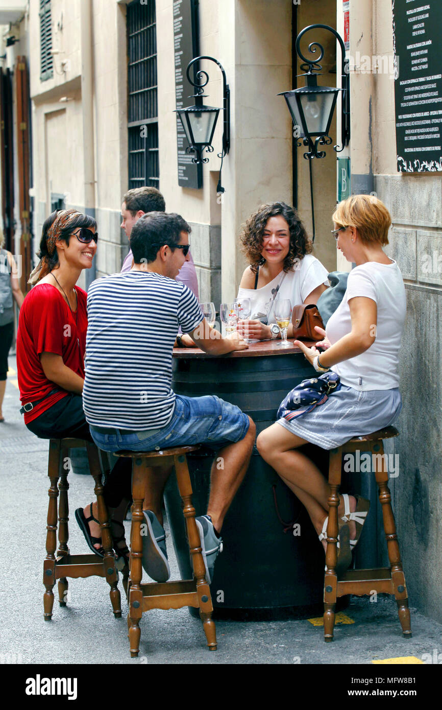 Amigos con una copa de vino fuera de El Cuerno, bar de tapas de Palma de Mallorca / Mallorca, Islas Baleares, España Foto de stock