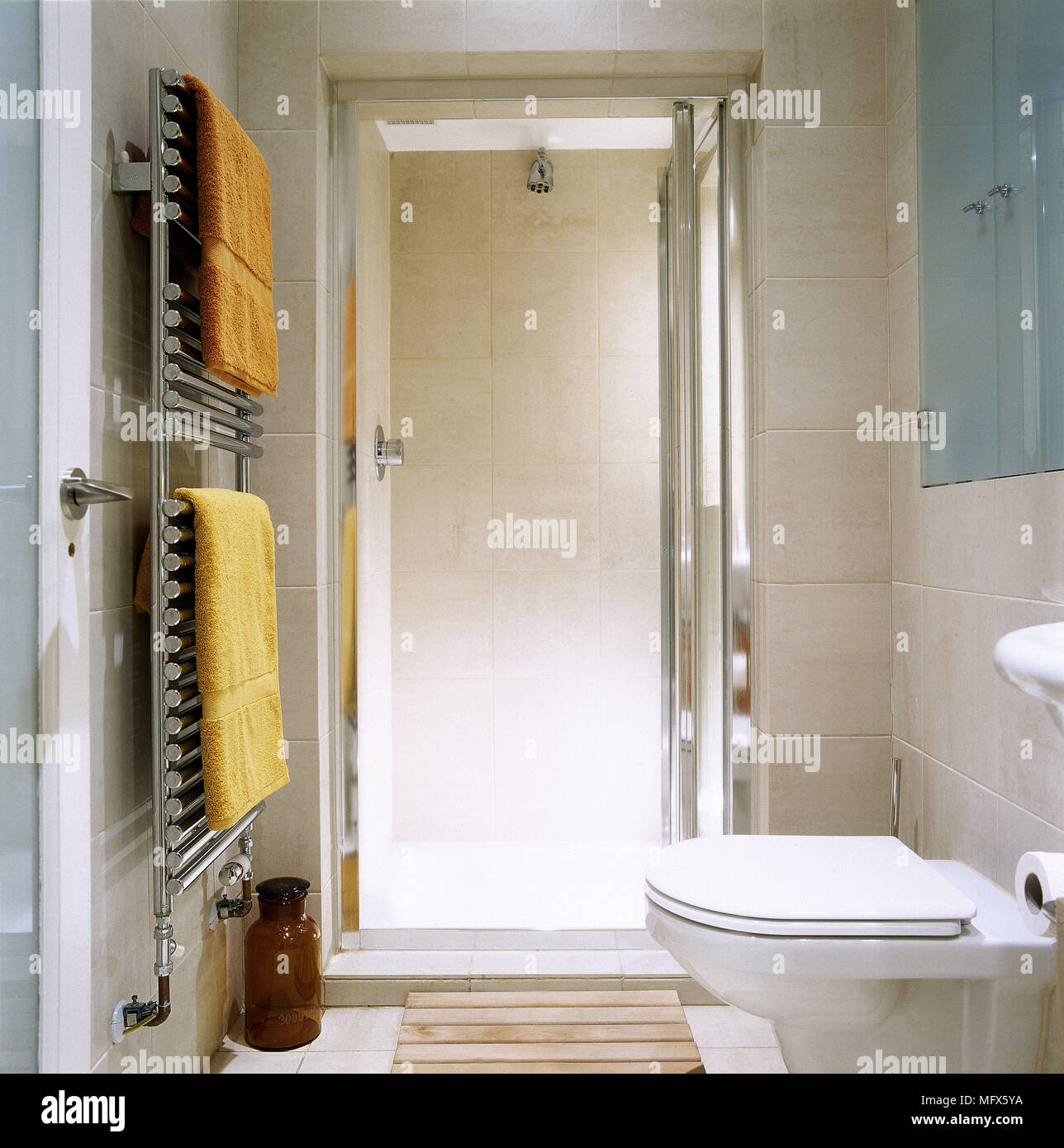 Moderno, baño con ducha, WC, toallas y cromo colgando de un calentador de  toallas Fotografía de stock - Alamy