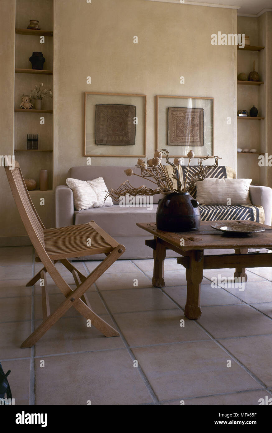 Salón moderno sofá piso de baldosas de piedra rústica mesa de café de  madera silla plegable interiores habitaciones materiales naturales colores  neutros Fotografía de stock - Alamy