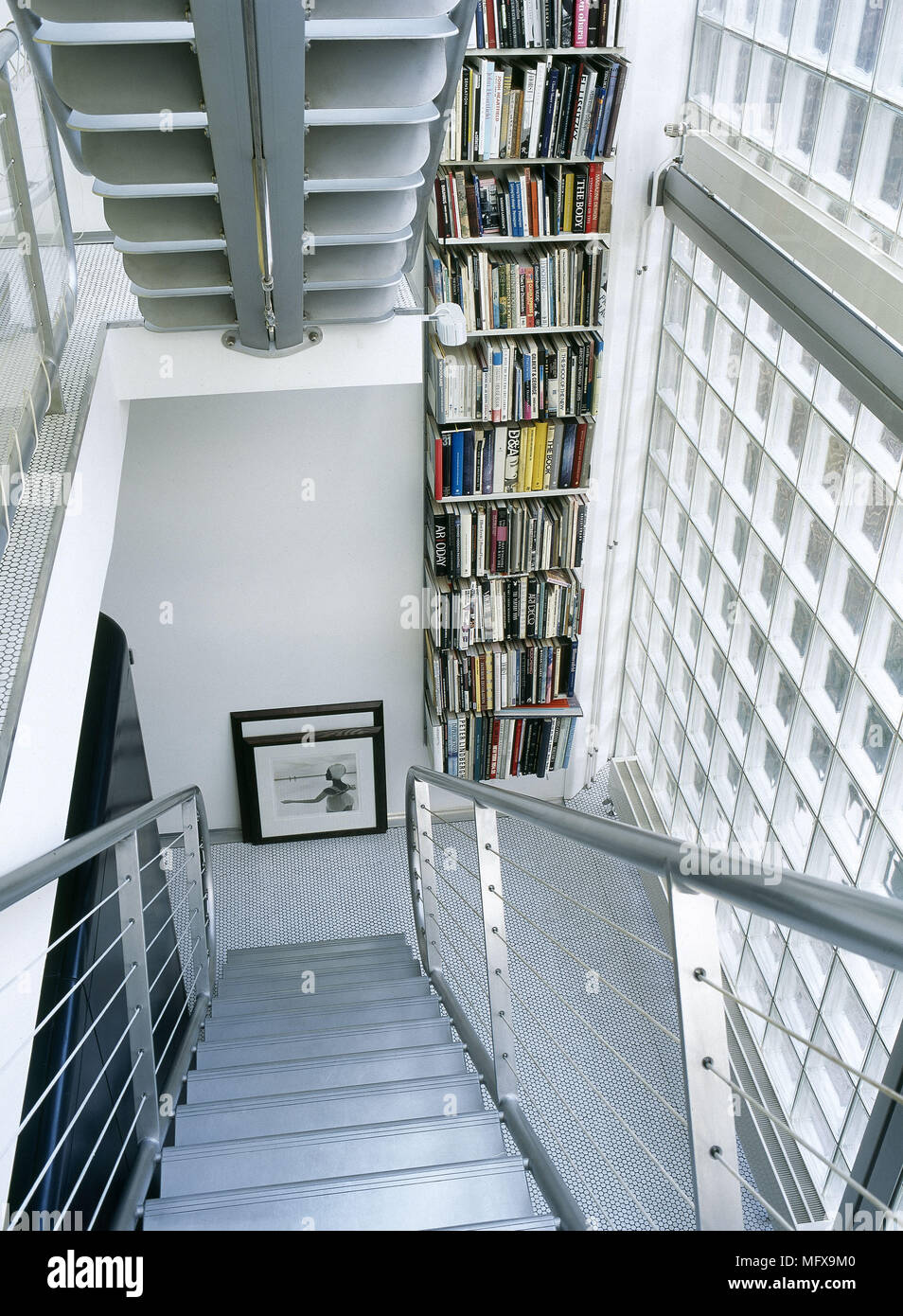 Moderna escalera con estantería y pared de ladrillos de vidrio Fotografía  de stock - Alamy