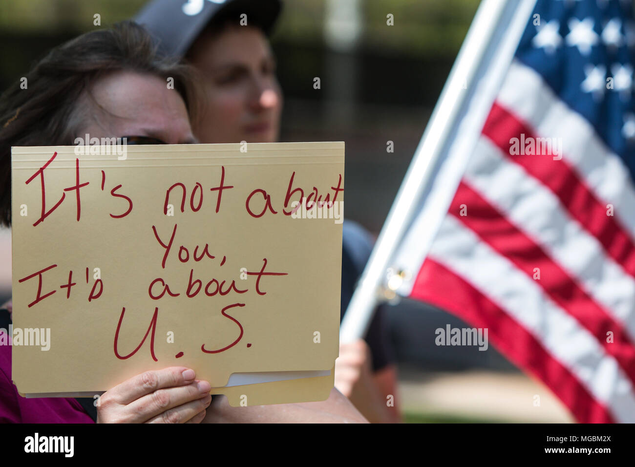 Una mujer sostiene letrero que dice "no es acerca de usted, se trata de EE.UU.' como ella escucha a los oradores en el Atlanta Marzo de impuestos el 15 de abril de 2017 en Atlanta. Foto de stock