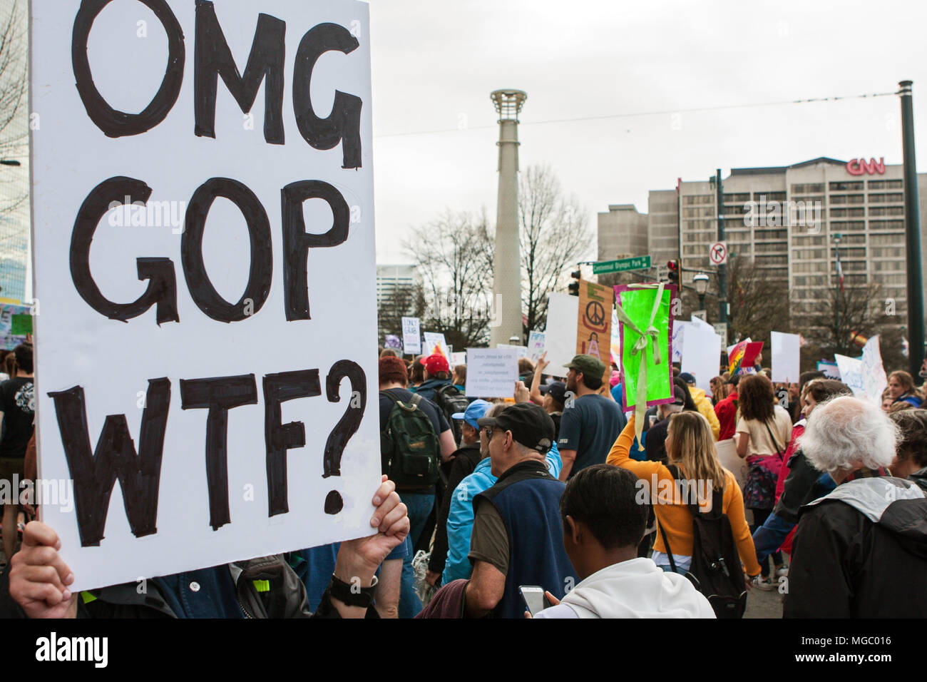 Una mujer sostiene un cartel que dice "OMG, GOP, WTF?' como pasar por miles de manifestantes en la marcha de las mujeres el 21 de enero de 2016 en Atlanta, GA. Foto de stock