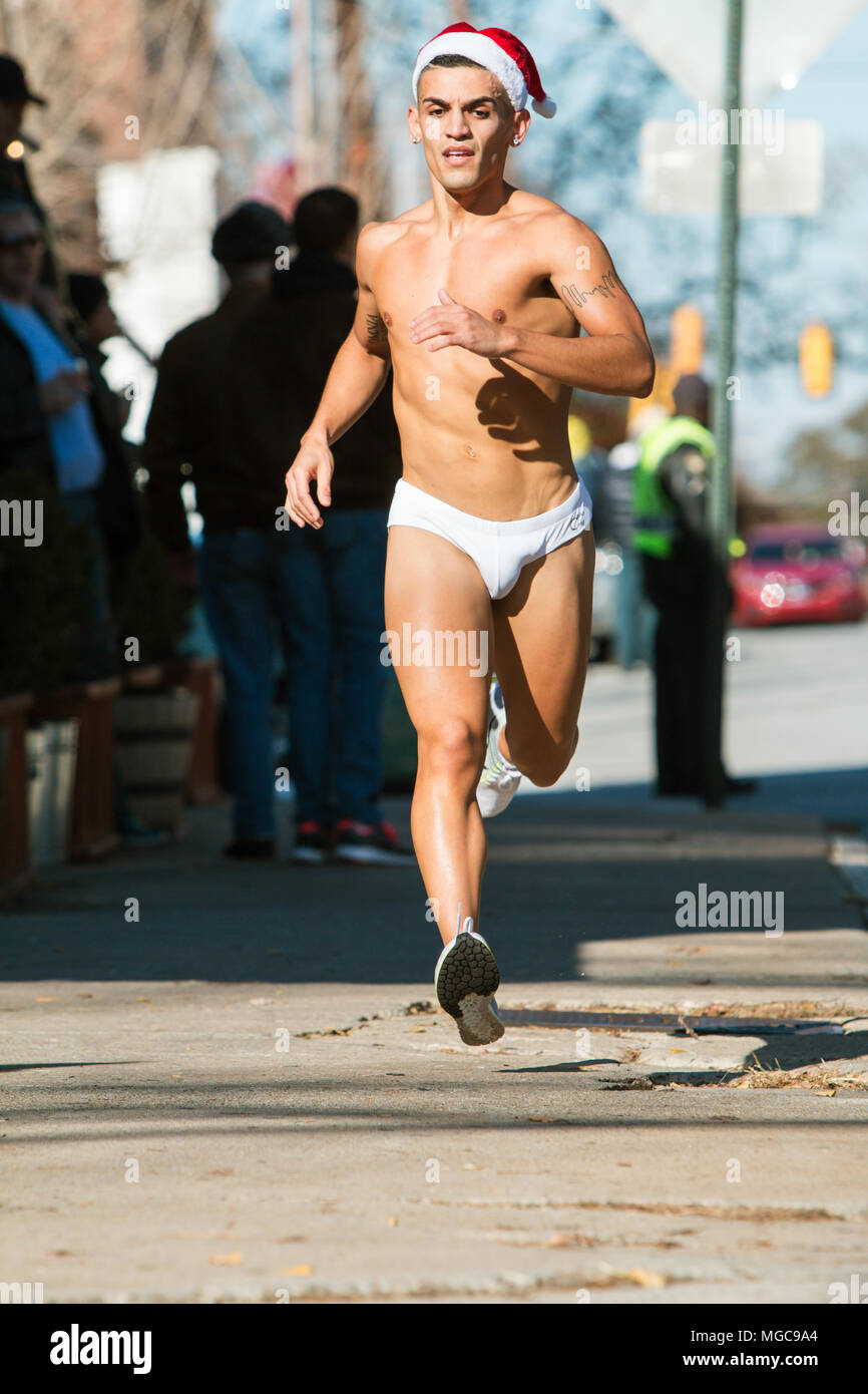 Un macho runner luciendo un bañador Speedo blanco avanza hacia abajo en una  calle de la ciudad en el Santa Speedo ejecutar, el 10 de diciembre de 2016  en Atlanta, GA Fotografía