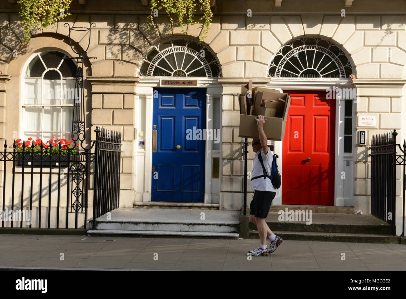 Hombre caminando por London Street, portando cajas de cartón sobre la cabeza, Londres, Inglaterra, Reino Unido. Foto de stock