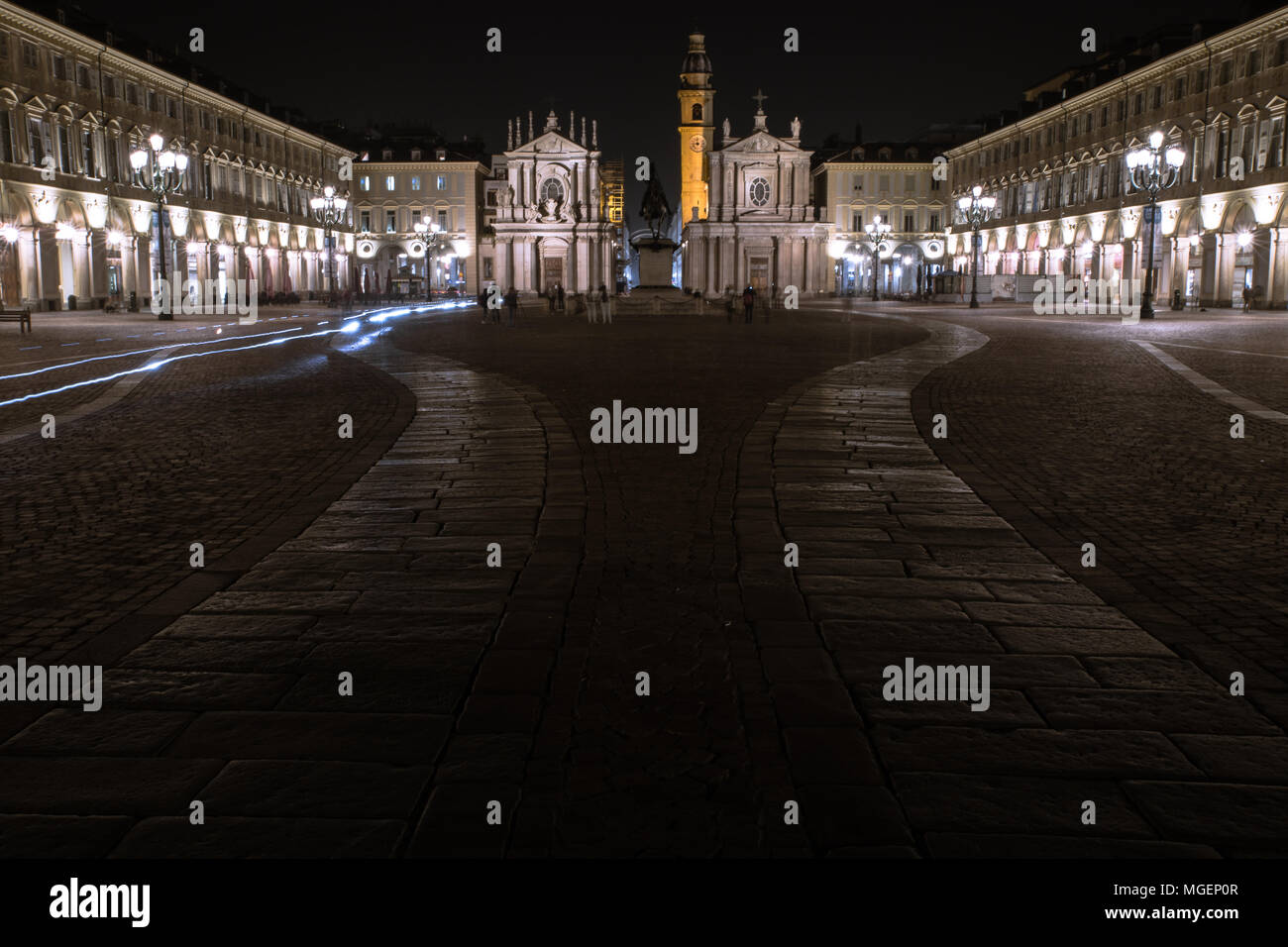 Una de las principales plazas de Turín, Piazza San Carlo, fotografiado en la noche mientras los faros de las motos whiz pasado los monumentos históricos Foto de stock