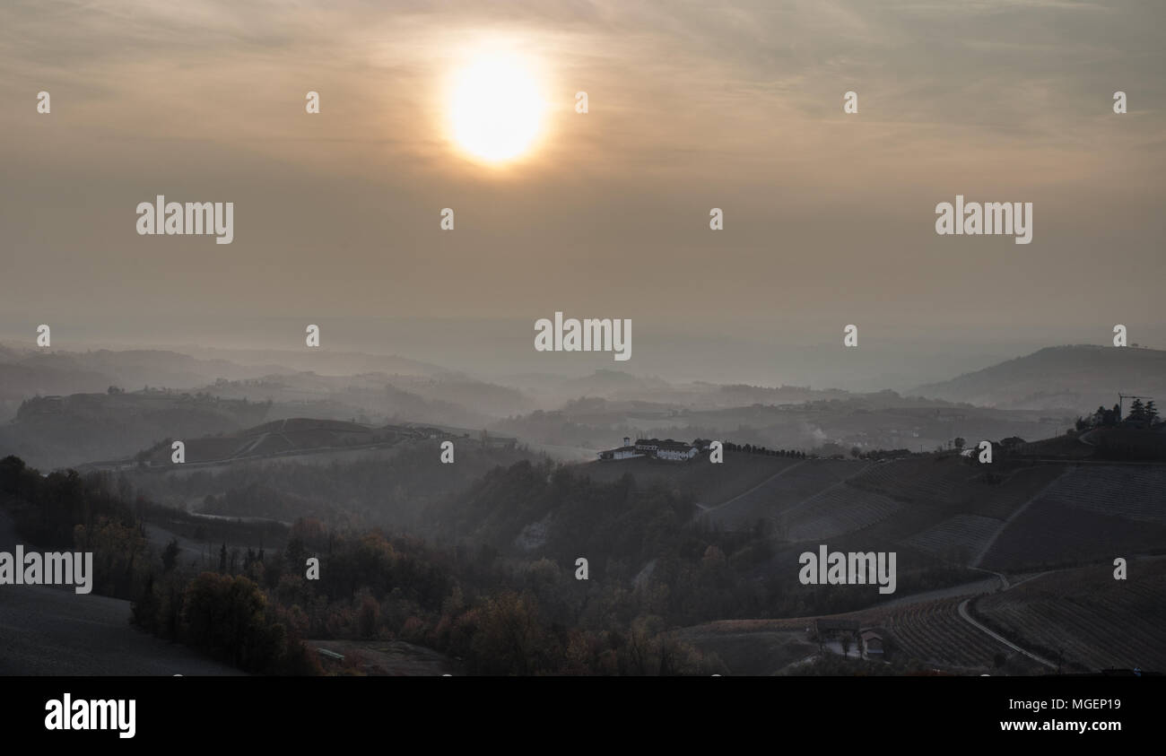 Una foto panorámica al atardecer en un día de niebla en la región de Langhe, en el Piamonte, una zona cerca de Turín, famosa por sus vinos y viñedos. Foto de stock