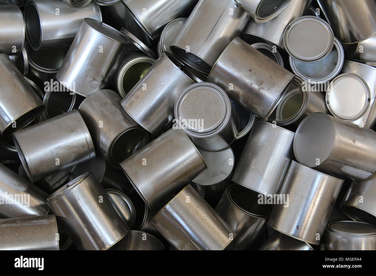 Acumulación de latas de estaño gris apilados unos encima de otros en una manera muy desordenado Foto de stock