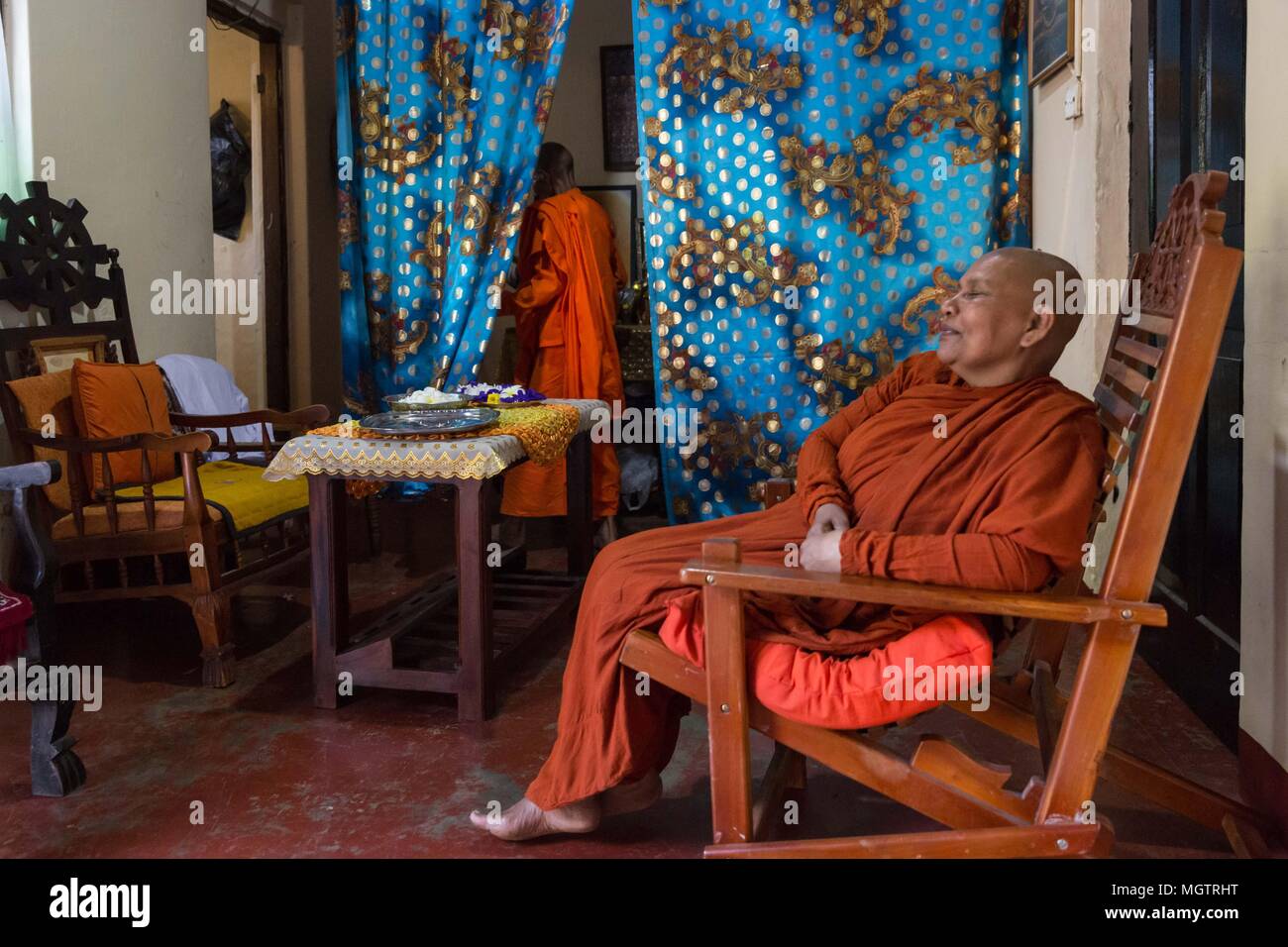 Kandy, Sri Lanka. 18 Feb, 2018. Monja budista, MOLAGODA GATHAMI MANIYO (R) observa a su madre, THALATHUWE UPEKA MANIYO, desapareciendo detrás de una cortina para prepararse para la noche de ofrendas al monasterio Aramaya Molagoda Gothami cerca de Kandy, Sri Lanka, el domingo, 18 de febrero de 2018. Crédito: Tracy Barbutes/Zuma alambre/Alamy Live News Foto de stock