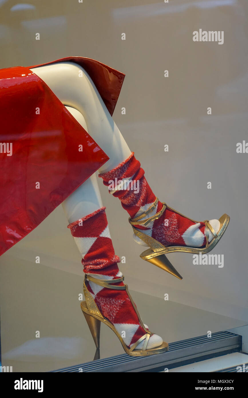 Chubasquero rojo calcetines y zapatos de tacón alto stiletto sobre un  maniquí en un escaparate Fotografía de stock - Alamy