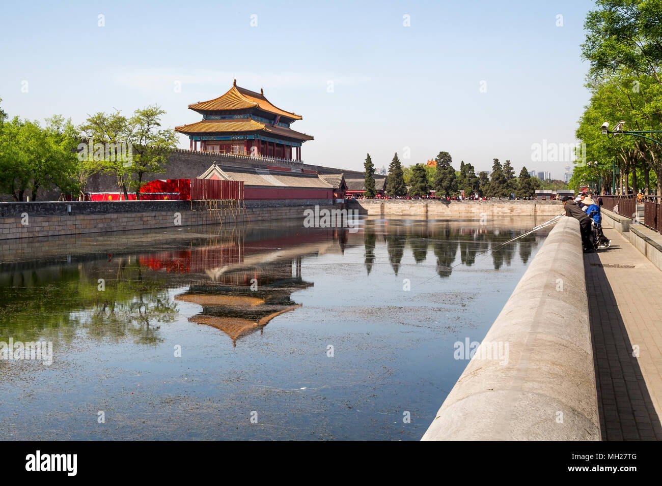 Un grupo de amigos a la captura de peces en el foso que rodea la Ciudad Prohibida en Beijing, China. En la distancia de la puerta del norte y de las multitudes de turistas. Foto de stock