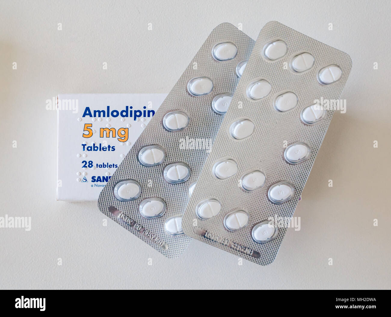 Pack de pastillas para el tratamiento de la hipertensión o presión sanguínea alta. Amlodipino (Norvasc) 5mg pastillas sobre fondo blanco. Foto de stock