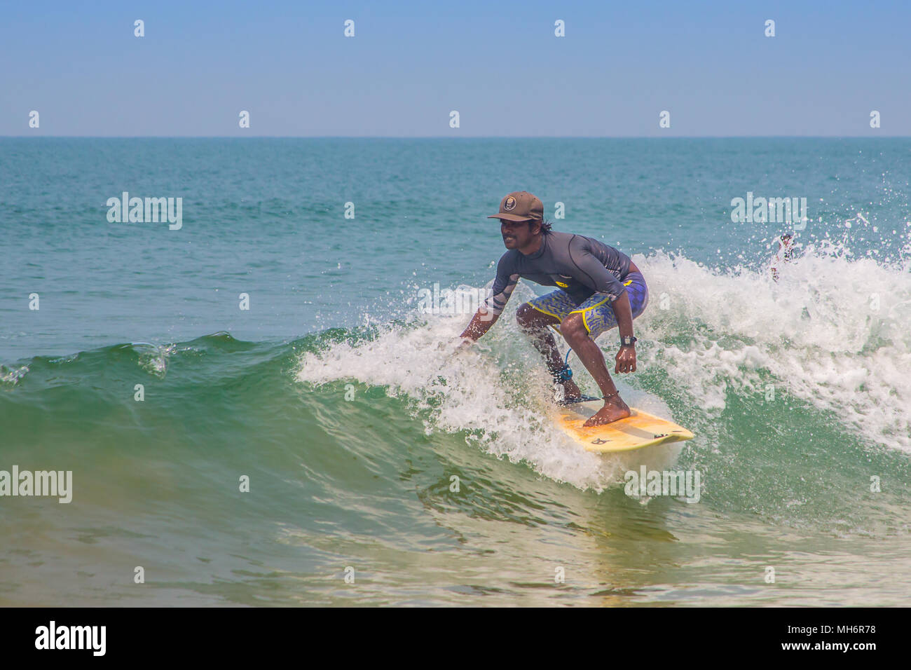 Velu, uno de Indias primer pro surfers, coger una ola en Agonda, Goa, donde tiene su escuela de surf. Foto de stock
