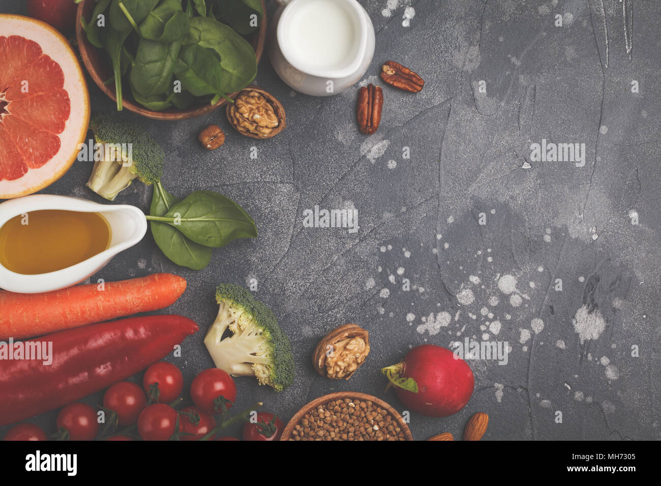 Fondo de alimentos sanos, productos de dieta alcalina de moda: frutas, verduras, cereales, nueces, aceite, fondo oscuro Foto de stock