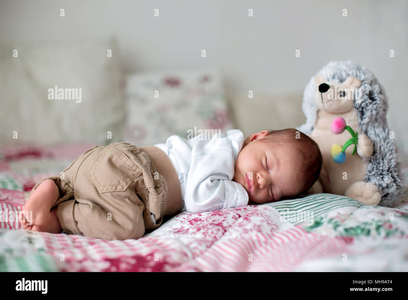 Pequeño y hermoso bebé recién nacido varón, vestido como poco señores,  dormir en la cama, lindo juguete junto a él Fotografía de stock - Alamy