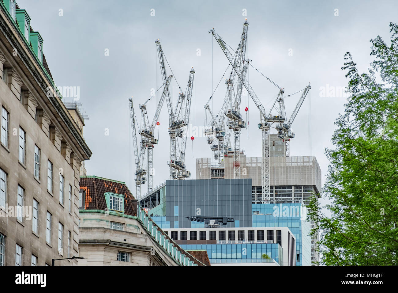 Grúas de construcción en la cima de un edificio en construcción en Londres, Inglaterra. Foto de stock