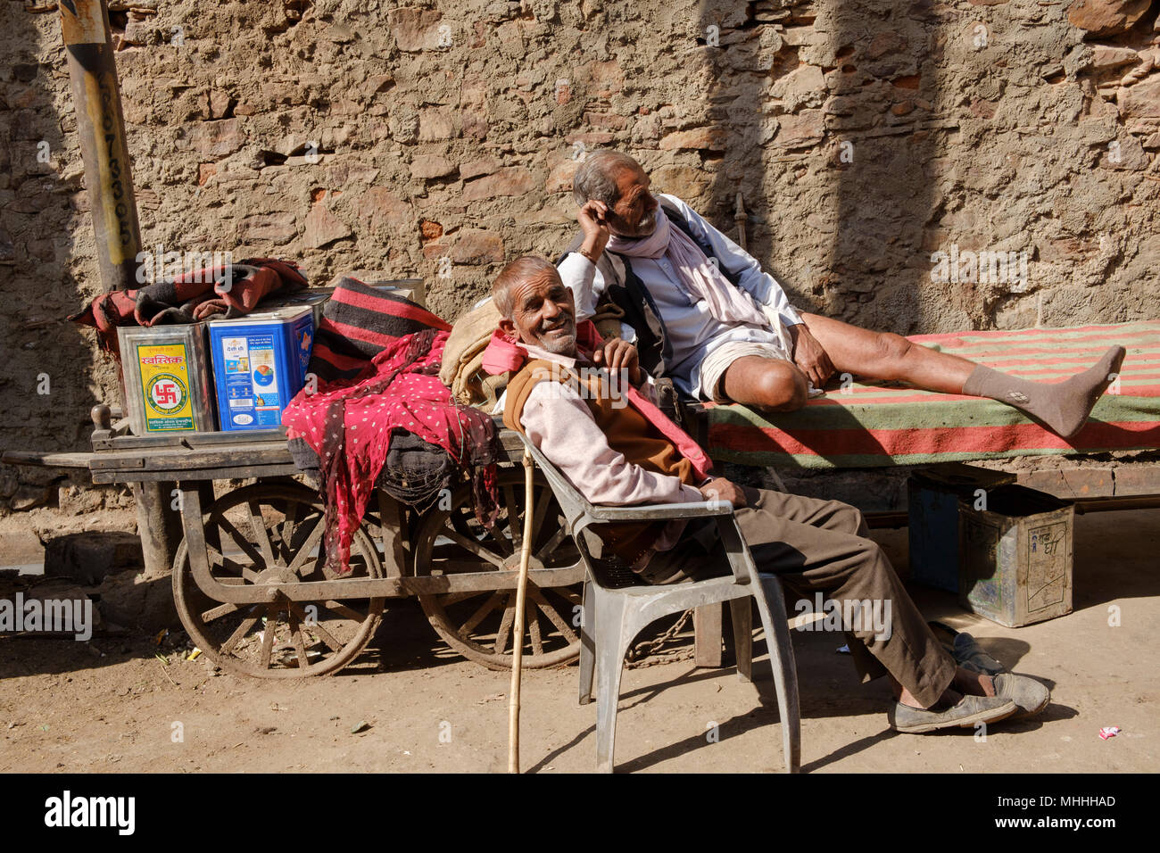 Dos hombres mayores para relajarse bajo el sol en la calle. Bundi, Rajasthan. La India Foto de stock