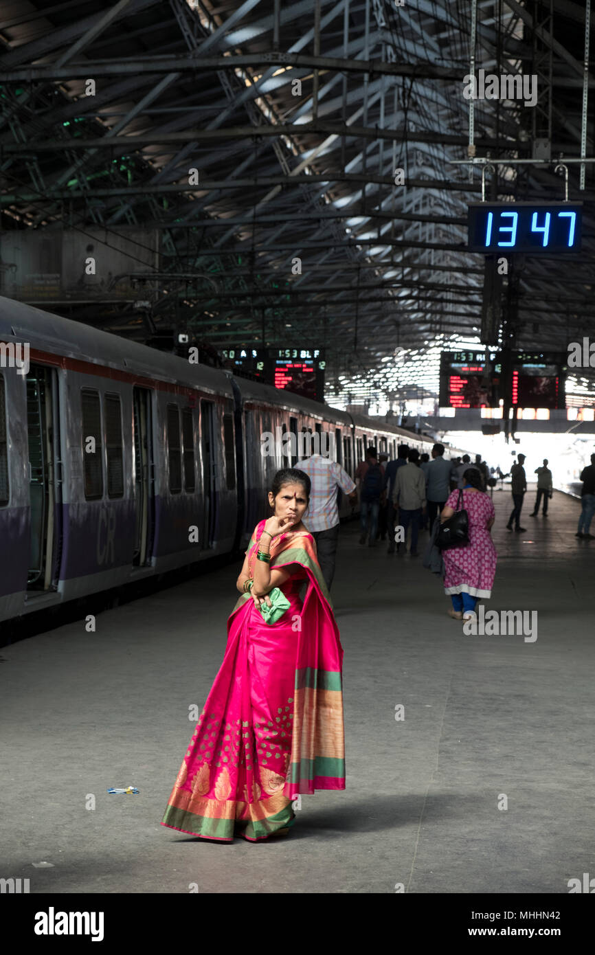 India - Mumbai - Mujer en una juerga esperando en la plataforma en el Chhatrapati Shivaji, anteriormente conocido como Victoria Terminus. La estación de trenes, es un sitio del Patrimonio Mundial de la Unesco. La estación fue diseñada por Frederick William Stevens según el concepto del renacimiento de la arquitectura gótica Italiana Victoriano y pretende ser un renacimiento similar de Indios Goth (época clásica) de la arquitectura. La estación fue construida en 1887 en Bori Bunder zona de Mumbai para conmemorar el jubileo de oro de la Reina Victoria Foto de stock