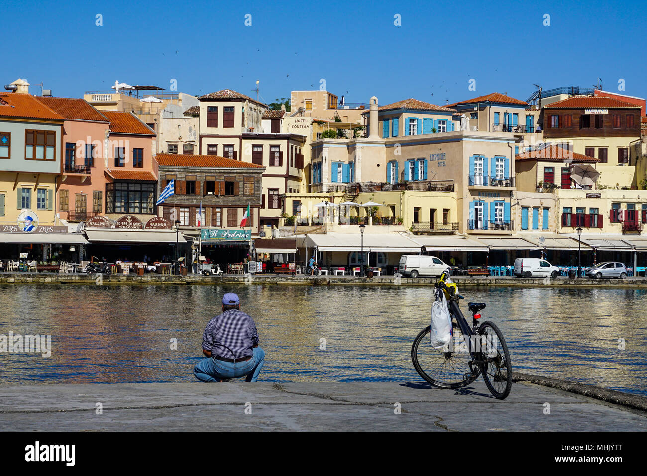 Hombre local con bicicleta en el puerto de Chania, en Creta Foto de stock