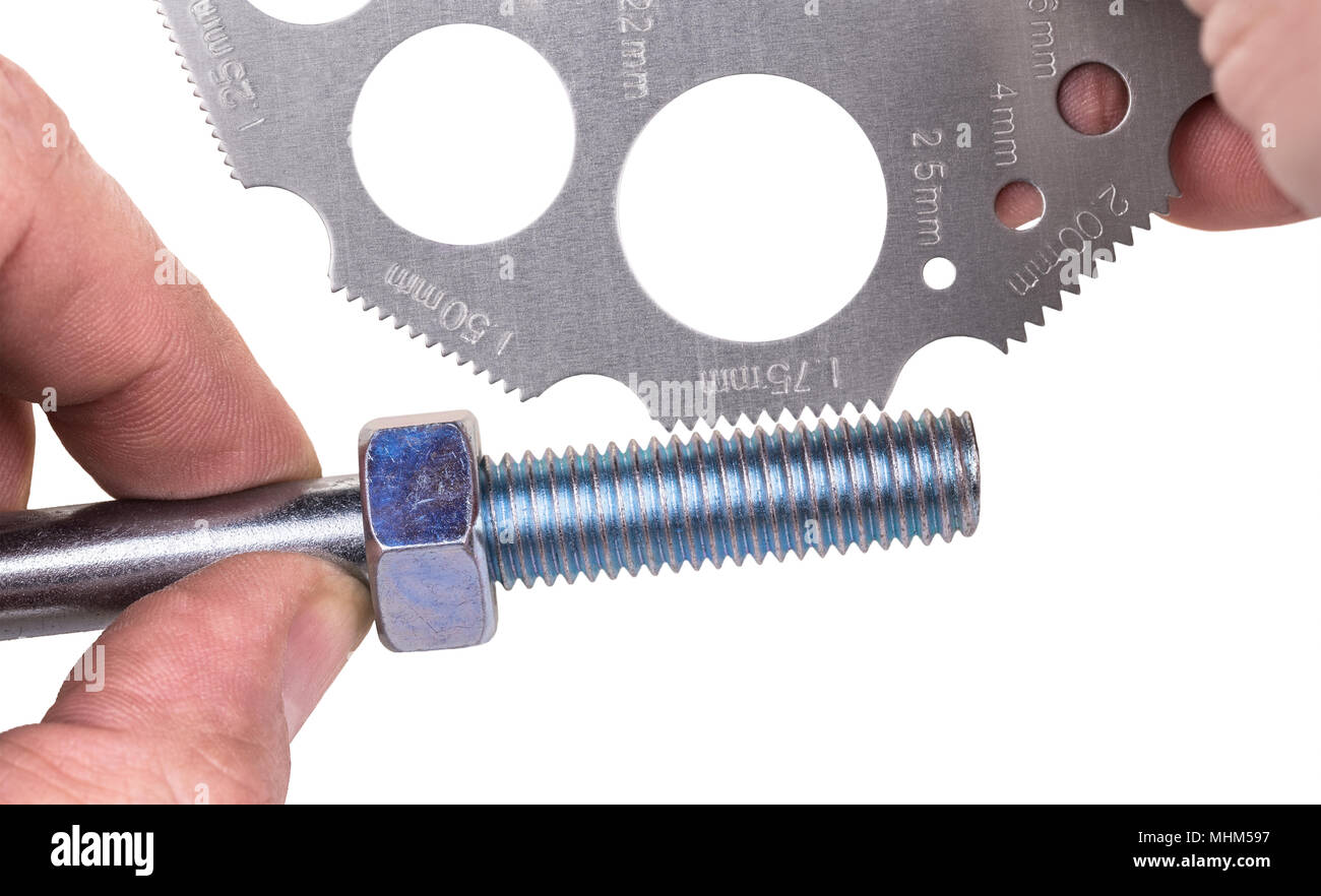 La medición por CALIBRADOR DE ROSCA en detalle. Close-up de herramienta de  medición. Las manos de expertos técnicos y medida de la rosca de la tuerca  y el tornillo de acero. Aislados
