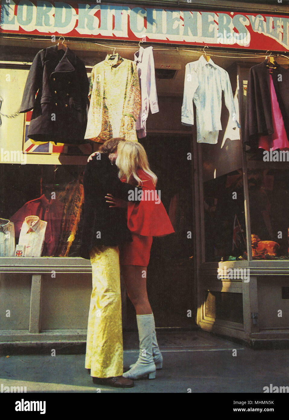 Una pareja besándose delante del icónico Carnaby Street boutique, yo era  Lord Kitchener's valet. Colgando fuera se puede apreciar una gran variedad  de ropa vintage de hombres incluyendo un peacoat naval y