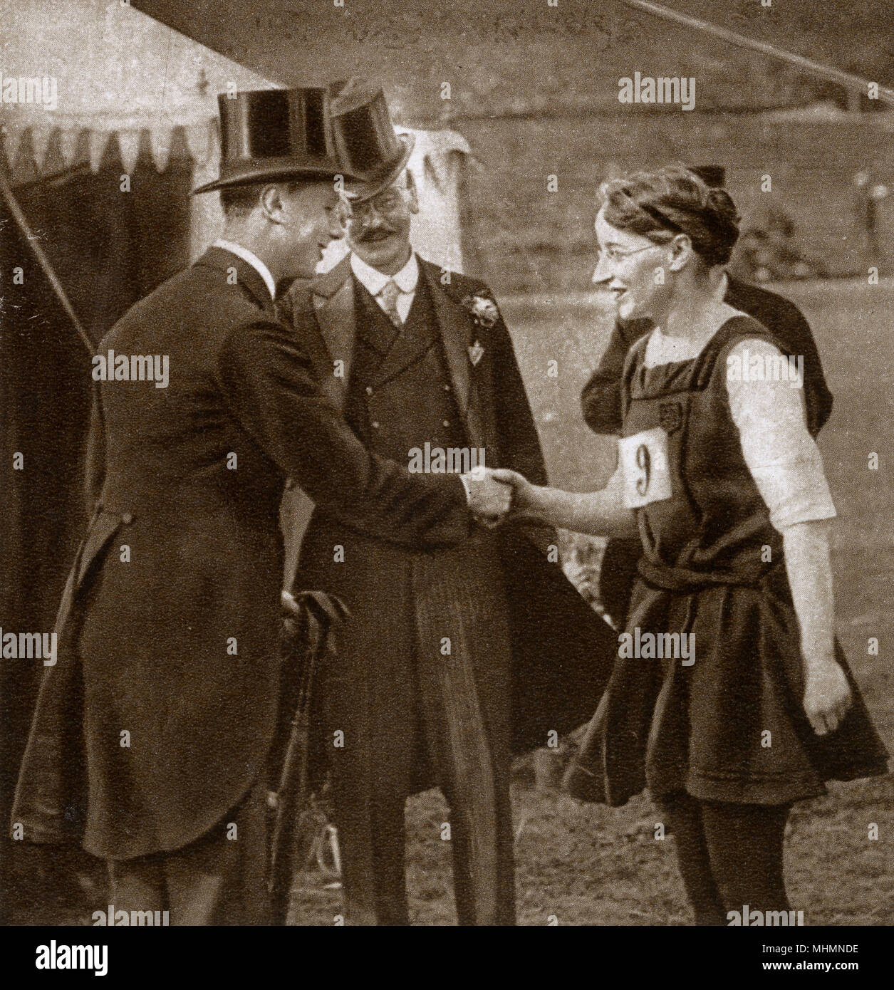 El Príncipe Alberto (futuro Rey George VI) (1895-1952), que recién se había convertido en duque de York visitando el Servicio Civil día deportivo en Stamford Bridge (el hogar de Chelsea Football Club). La imagen le muestra un apretón de manos con la Srta. D. Leach, un competidor. Fecha: 1920 Foto de stock