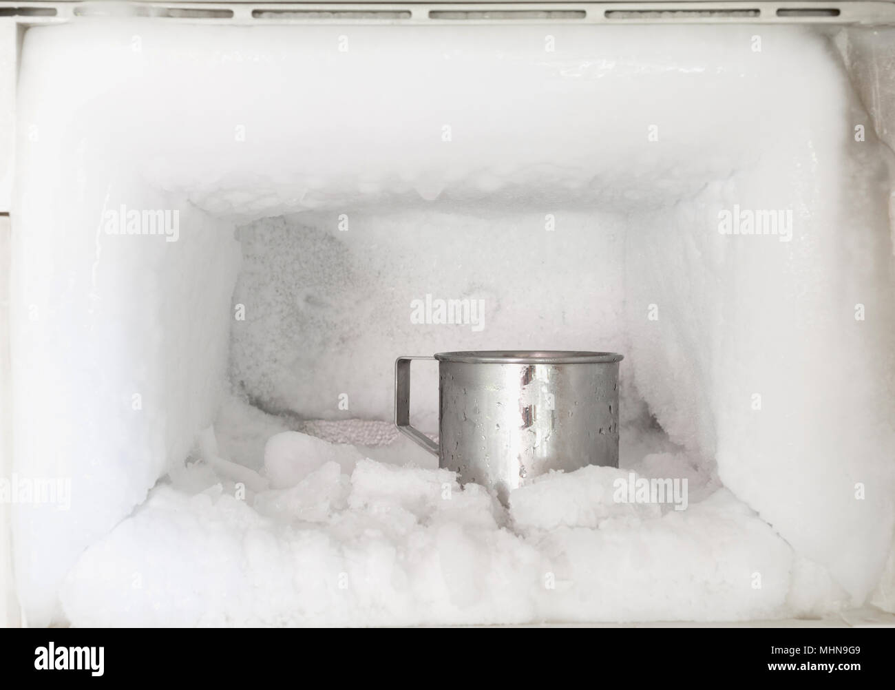 Acero inoxidable cristal de agua potable en el congelador de una nevera. La  acumulación de hielo dentro de un congelador paredes Fotografía de stock -  Alamy