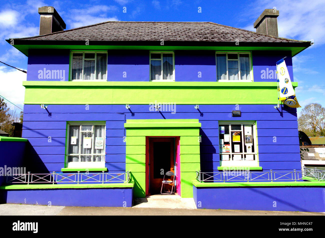 Edificio de ladrillo de colores brillantes o de color azul claro y verde , una antigua casa nacional de pie en el sol del mediodía. Foto de stock