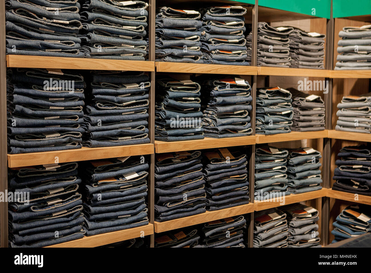 Pantalones vaqueros en la estantería de la tienda. Blue jeans denim jeans  Colección apiladas Fotografía de stock - Alamy