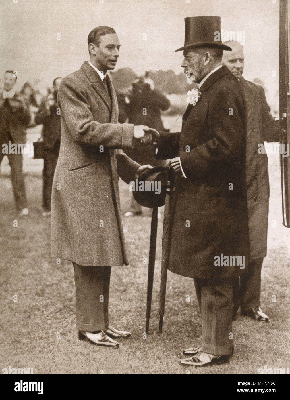 Duque de York y padre King George V salúdense los unos a los otros en el royal show de caballos, Richmond antes de salir a inspeccionar los mejores caballos pura sangre en la tierra. Fecha: 1928 Foto de stock