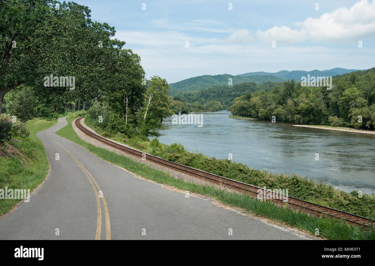 Las rutas de transporte de los apalaches: las vías de ferrocarril y una carretera rural siga al borde de un río en las montañas del este de Tennessee. Foto de stock