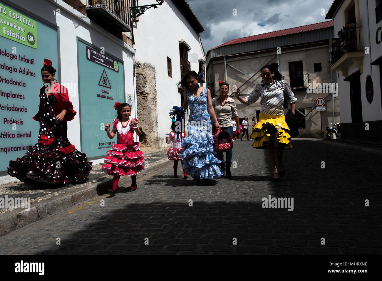Las mujeres vestidas con traje de flamenca típica caminando por las calles  del barrio de Albaicín. "El día de la Cruz" o "Día de las Cruces" es una de  las más bellas