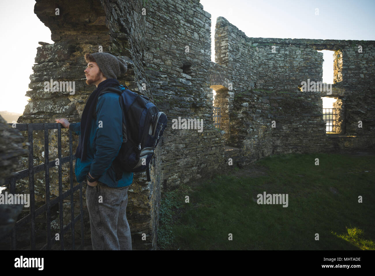Excursionista masculina de pie en ruina en el campo Foto de stock