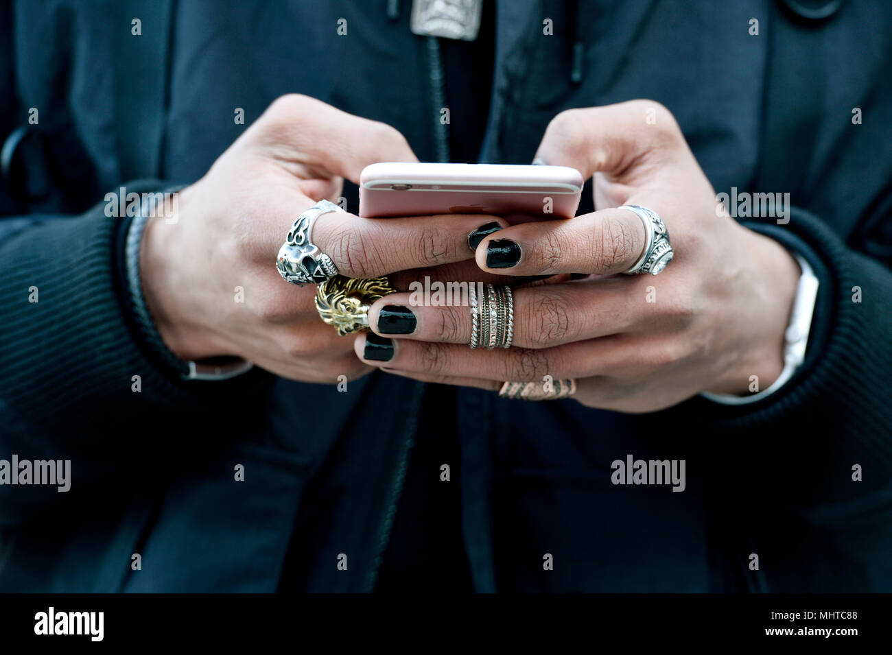 Un hombre con las manos llenas de anillos manipulando un smartphone - París  - Francia Fotografía de stock - Alamy