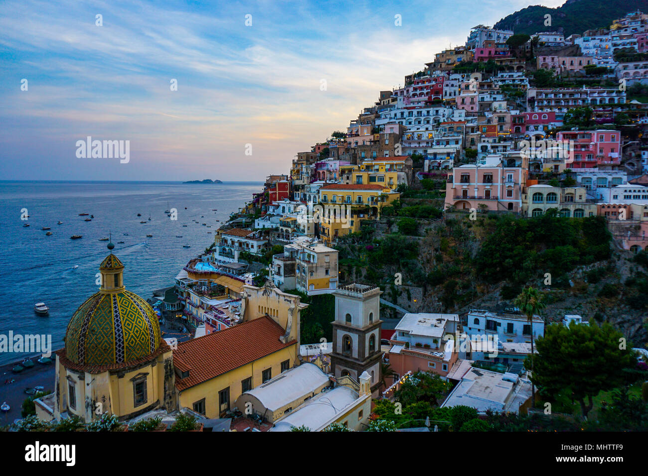 Vista de Positano, Amalfi Coast, Italia al atardecer con el domo de la Chiesa di Santa Maria Assunta en primer plano Foto de stock