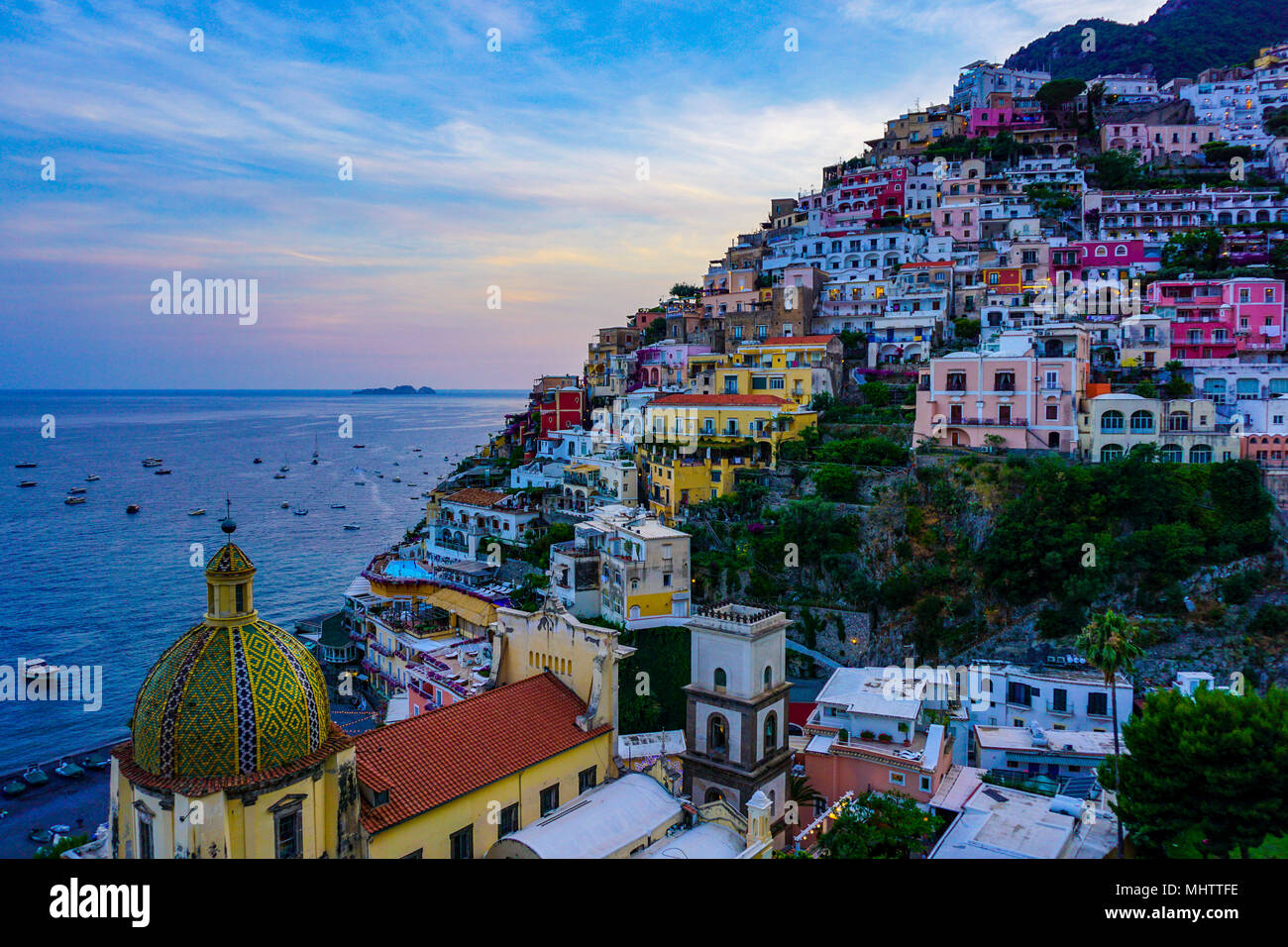 Vista de Positano, Amalfi Coast, Italia al atardecer con el domo de la Chiesa di Santa Maria Assunta en primer plano Foto de stock