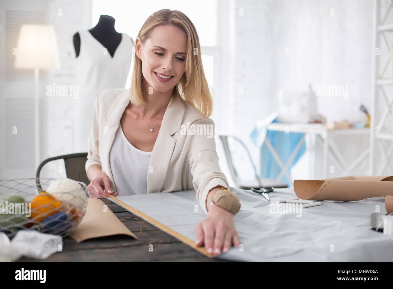 Modista femeninos positivos medición de longitud Foto de stock