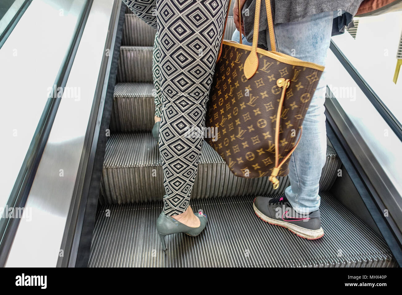 Una atractiva mujer que llevaba un Hermes Birkin handbag camina delante de  una enorme Louis Vuitton (LV) maleta fuera del centro comercial Plaza 66 en  Shanghai, China, 4 Fotografía de stock - Alamy