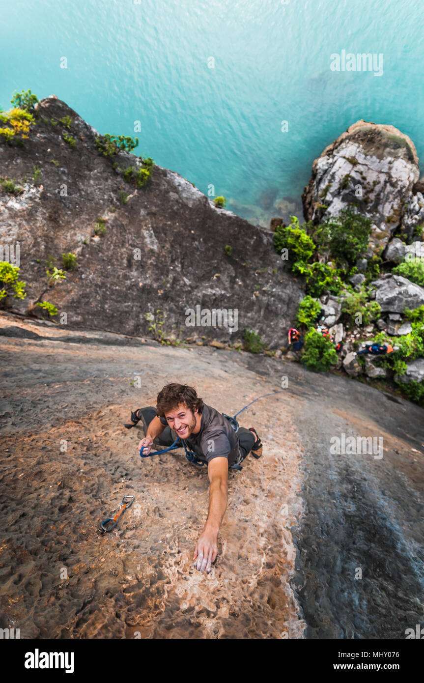 Hombre, la escalada en roca caliza, vista aérea, la bahía de Ha Long, Vietnam Foto de stock