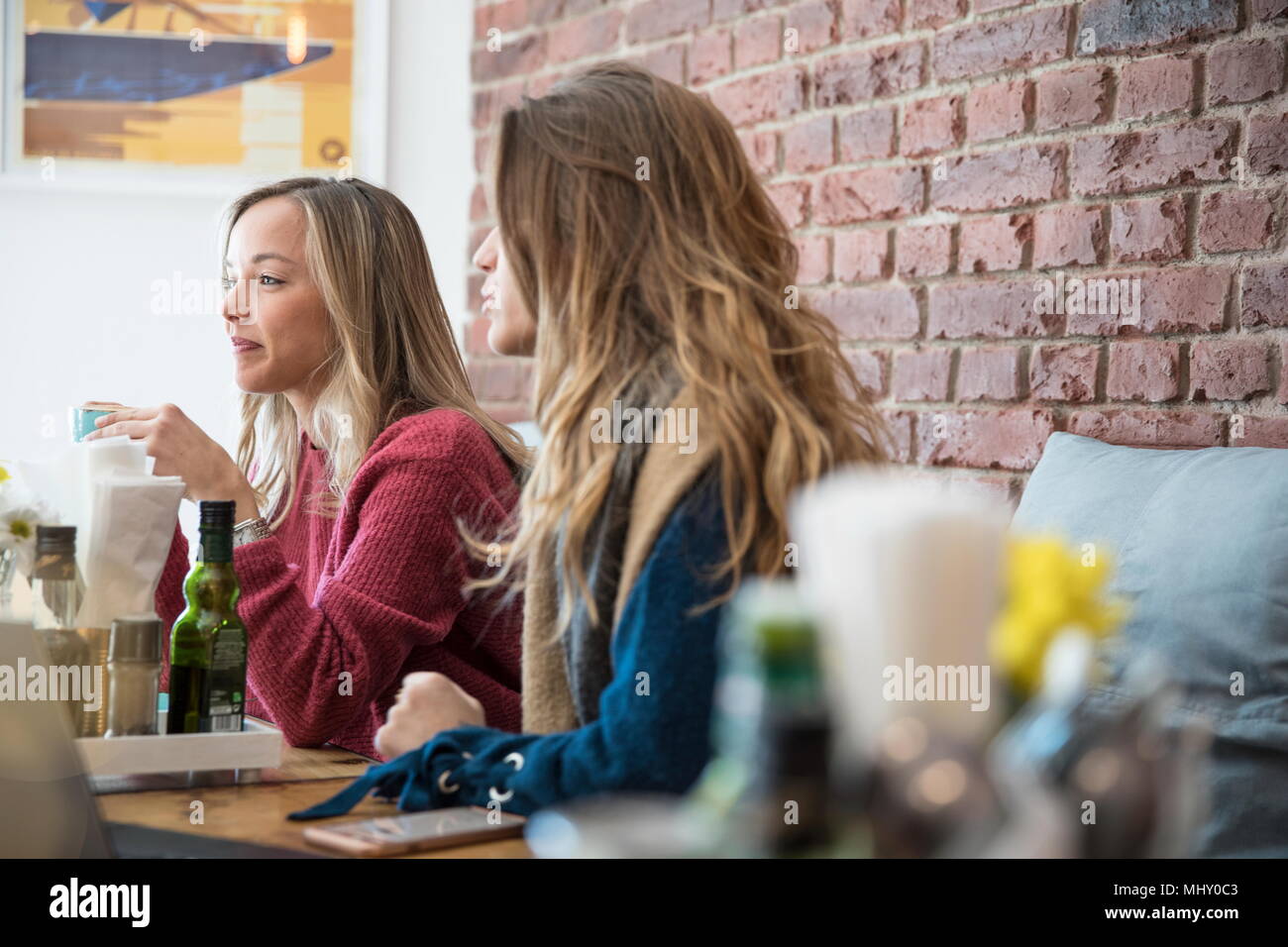 Amigas sentado en la cafetería, bebiendo café Foto de stock