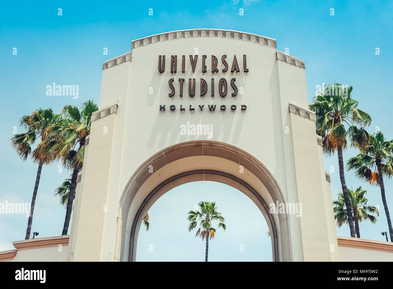 Los Angeles/California/EE.UU. - 07.19.2013: puerta de entrada de los Universal Studios Hollywood, cielo azul y palmeras en el lado de la puerta. Foto de stock