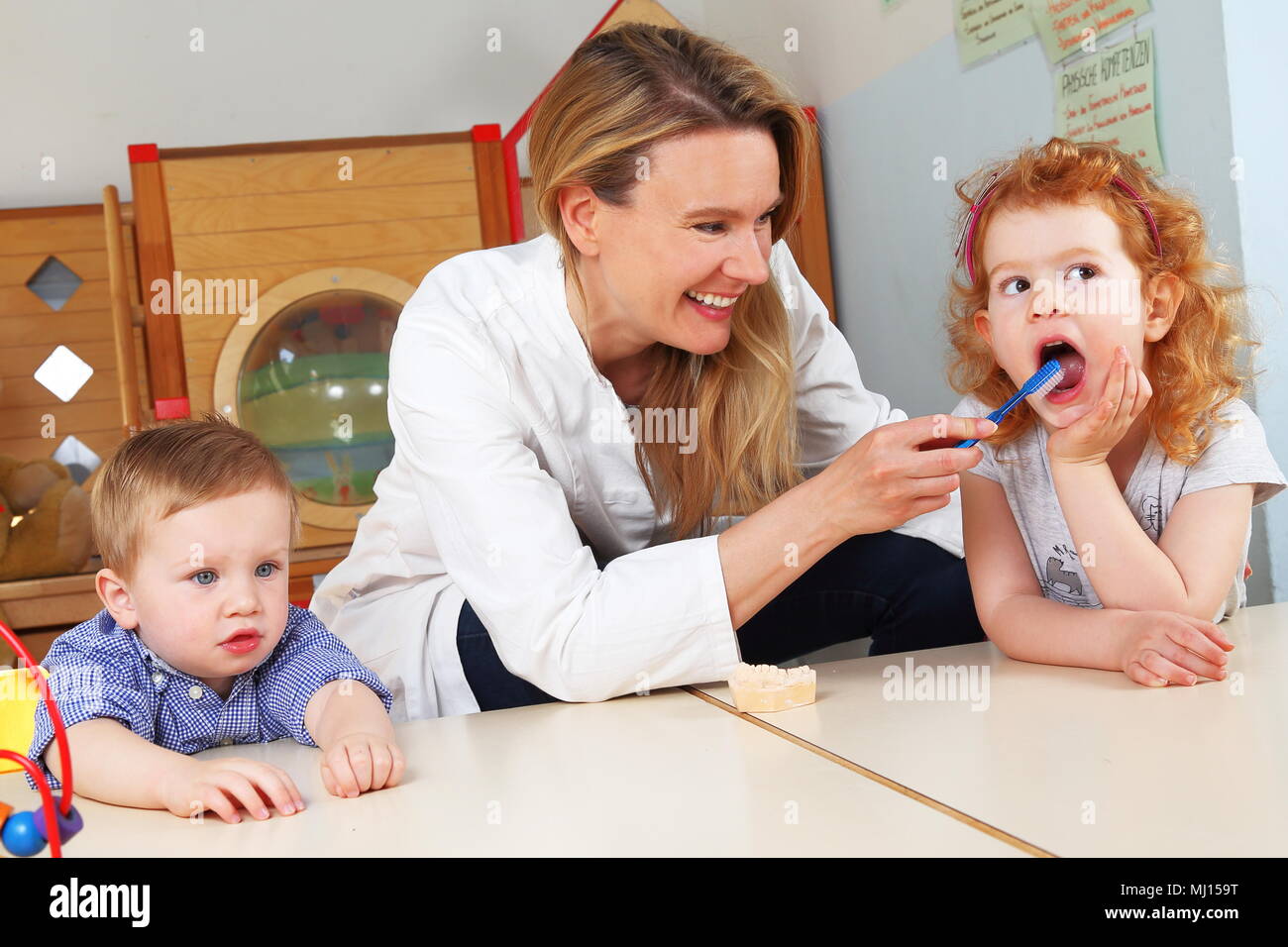 Un odontólogo cepillarse los dientes en Kindergarten. Foto de stock