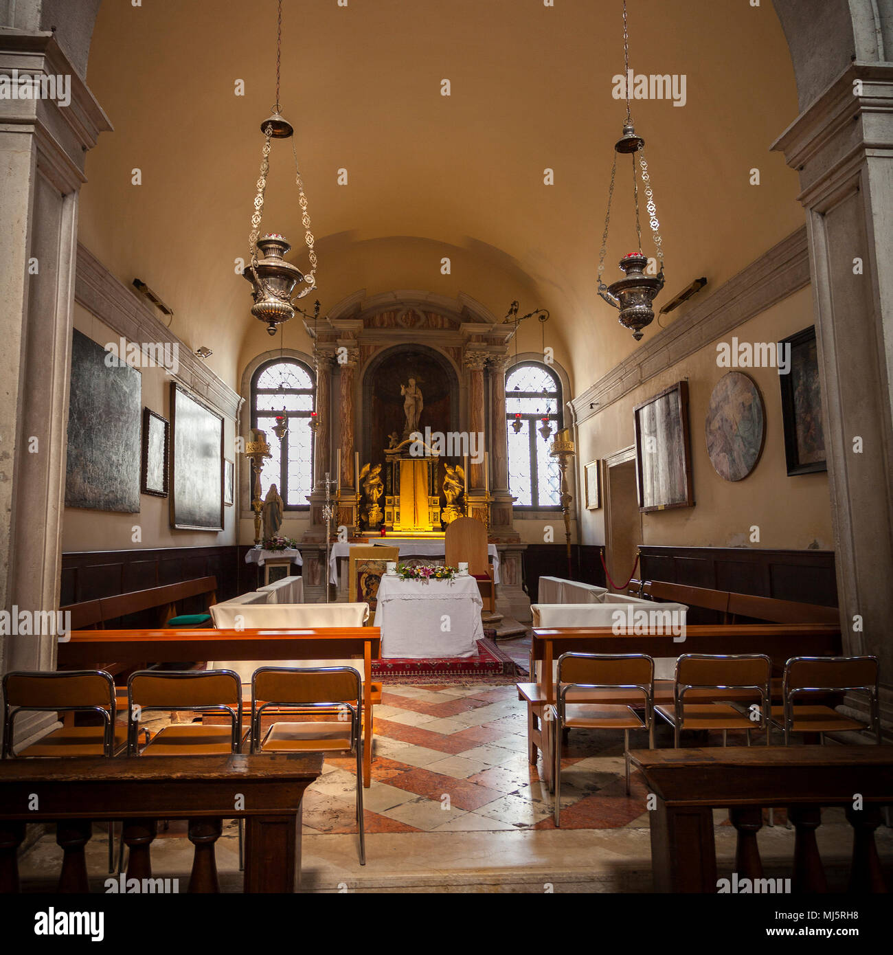 Modesto interior de una de las muchas iglesias católicas en Venecia,  Italia. Una antigua interiores en un estilo tradicional con pinturas en las  paredes Fotografía de stock - Alamy